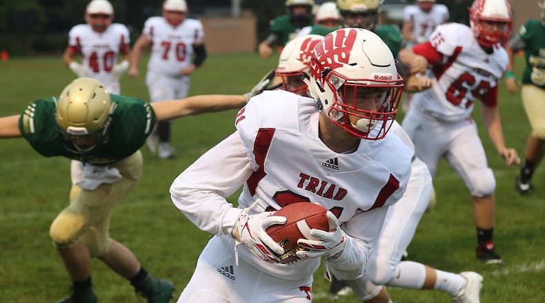 Triad’s Isaiah Bruce carries the ball after making a reception against Catholic Central. BILL LACKEY/STAFF
