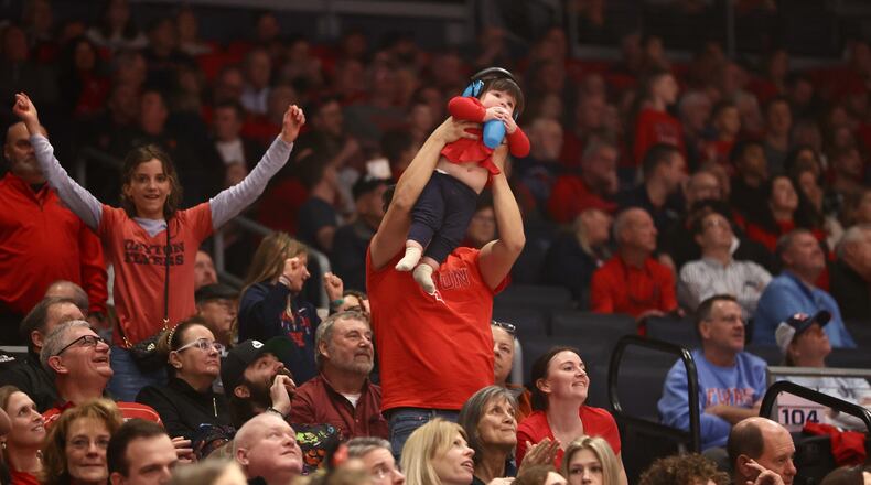 A Day fan holds up a child during a game against Richmond on Saturday, Jan. 28, 2023, at UD Arena. David Jablonski/Staff