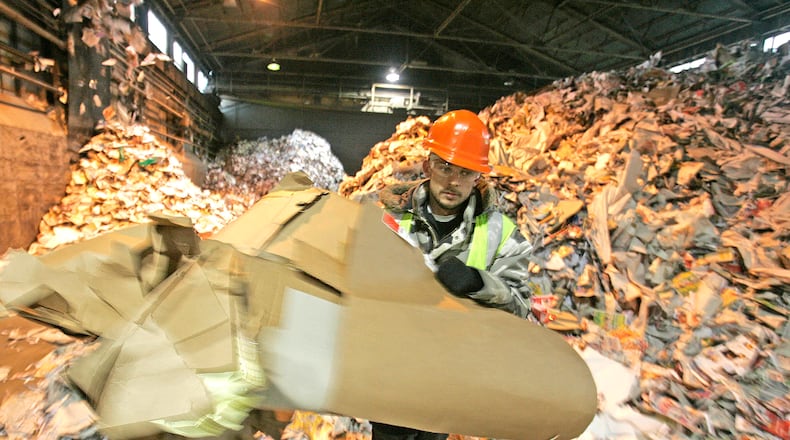 Rumpke Recycling worker Tim Stoops move recycling material around the Rumpke Recycling Center at 1800 East Monument Ave. in this 2008 file photo.