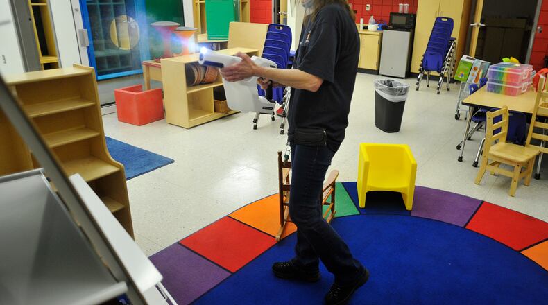 Betty Clark, a custodian for Beavercreek schools, disinfects a preschool classroom with a chlorination gun. Beavercreek was listed as having five student COVID-19 cases last week among its 7,000-plus students. MARSHALL GORBY\STAFF