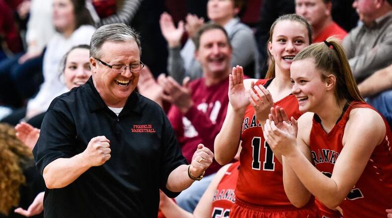 John Rossi, who coached girls basketball at Fenwick, Middletown, Madison and Franklin high schools, compiled an overall record of 336-221. Here, he celebrates his team’s Division II sectional championship with Kristin Earles (11) and Madison Earles (22) late in the game against Monroe at Lebanon. NICK GRAHAM/STAFF