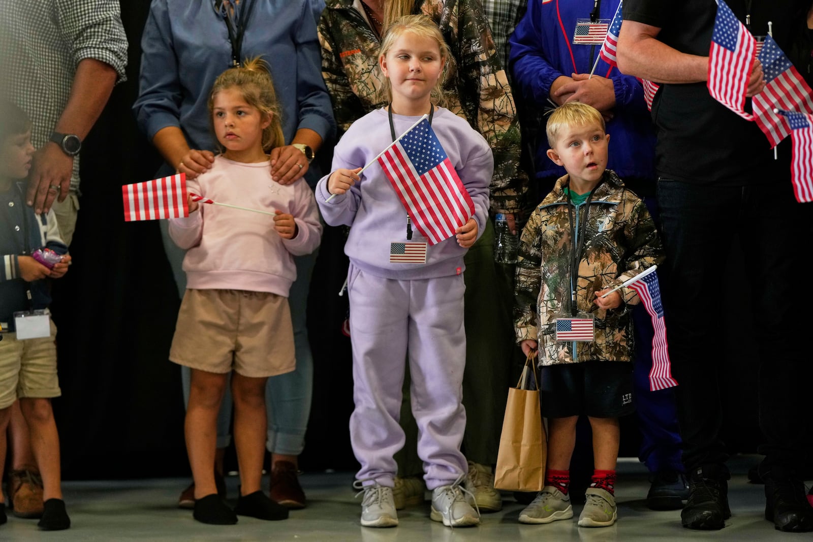 Young Afrikaner refugees from South Africa holding American flags arrive, Monday, May 12, 2025, at Dulles International Airport in Dulles, Va. (AP Photo/Julia Demaree Nikhinson)