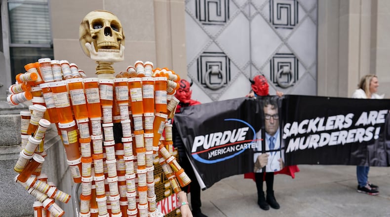 FILE - "Pill Man" made by Frank Huntley of Worcester, Mass., from his opioid prescription pill bottles, is displayed during a protest by advocates for opioid victims outside the Department of Justice, Dec. 3, 2021, in Washington. (AP Photo/Carolyn Kaster, File)