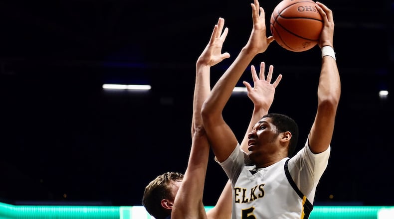 Centerville’s Mo Njie puts up a shot against Moeller during Wednesday’s Division I regional semifinal game at Cintas Center in Cincinnati. Nick Graham/STAFF