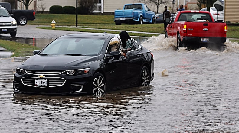 A woman was trapped in high water on Hillary Street in Trotwood as record rain fell on the region Tuesday. MARSHALL GORBY/STAFF