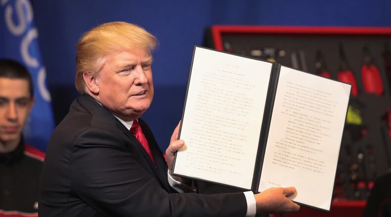 President Donald Trump signs an executive order to try to bring jobs back to American workers and revamp the H-1B visa guest worker program during a visit to the headquarters of tool manufacturer Snap-On on April 18 in Kenosha, Wisconsin. (Photo by Scott Olson/Getty Images)