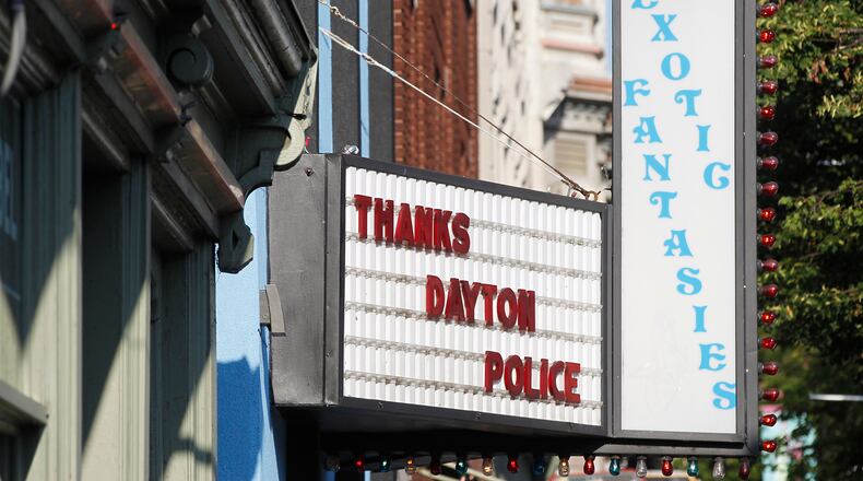 Memorials to the Dayton shooting victims filled the sidewalks of the Oregon District on Monday morning in the wake of 10 people being killed, including the shooter, and more than two dozen injured shortly after 1 a.m. Sunday. A sign recognizes the actions of six Dayton police officers who fired shots and killed the gunman as he tried to enter a bar. TY GREENLEES / STAFF