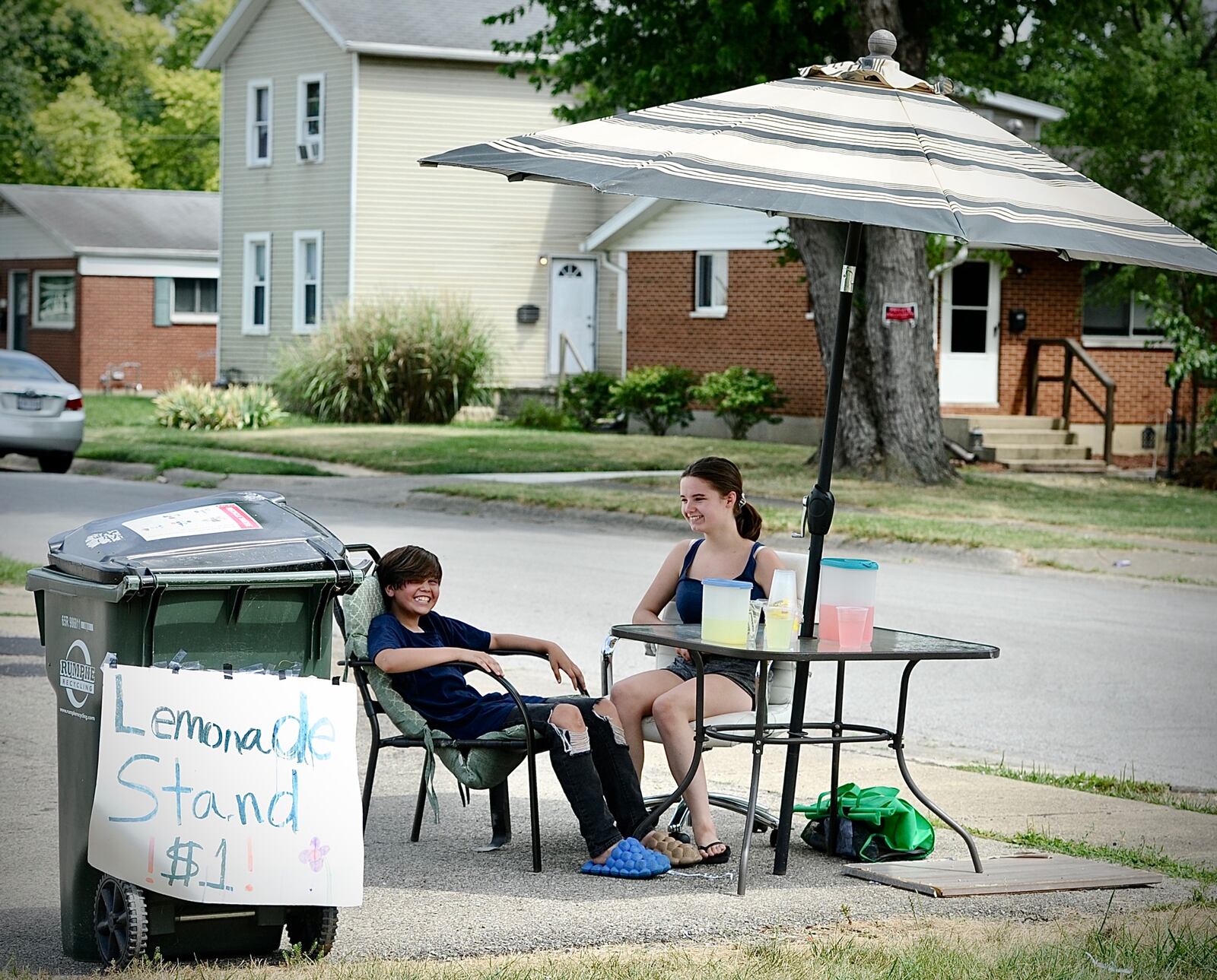 A way to beat the heat and make some money: Emma Guernsey, age 11, and Jazlynn Hambidge, age 13, set up a lemonade stand on Kauffman Avenue in Fairborn on Tuesday, June 18, 2024. MARSHALL GORBY \STAFF