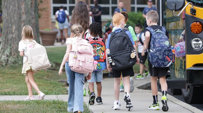 Students walk toward Cline Elementary School after exiting a school bus on Wednesday, Aug. 12 in Centerville. Centerville got a 5-star rating on the latest round of report cards for the 2024-2025 school year. BRYANT BILLING / STAFF