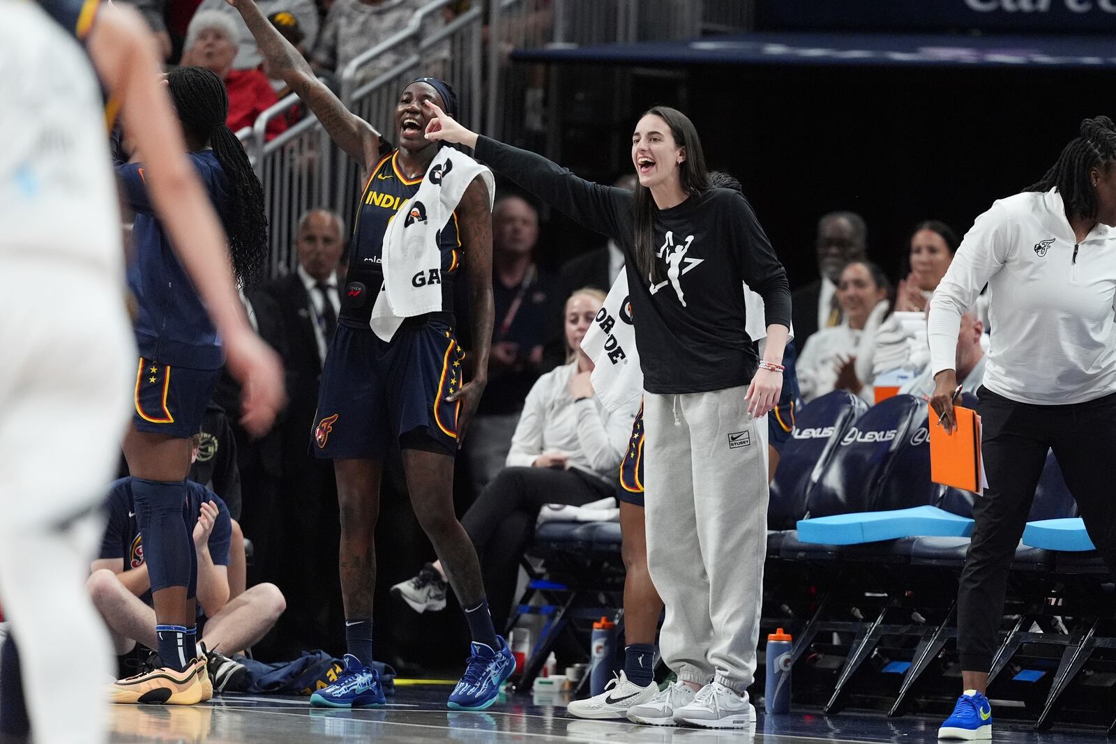 Indiana Fever's Caitlin Clark, right, cheers during the second half of a WNBA basketball game against the Las Vegas Aces, Thursday, July 3, 2025, in Indianapolis. (AP Photo/Michael Conroy)