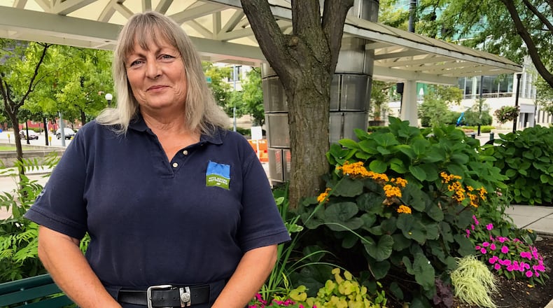 Cinda Plante stands for a photo in front of a bed of flowers at Riverscape Metropark.