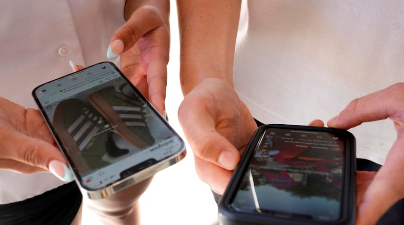 FILE - Young people use their phones to view social media in Sydney, Nov. 8, 2024. (AP Photo/Rick Rycroft, File)