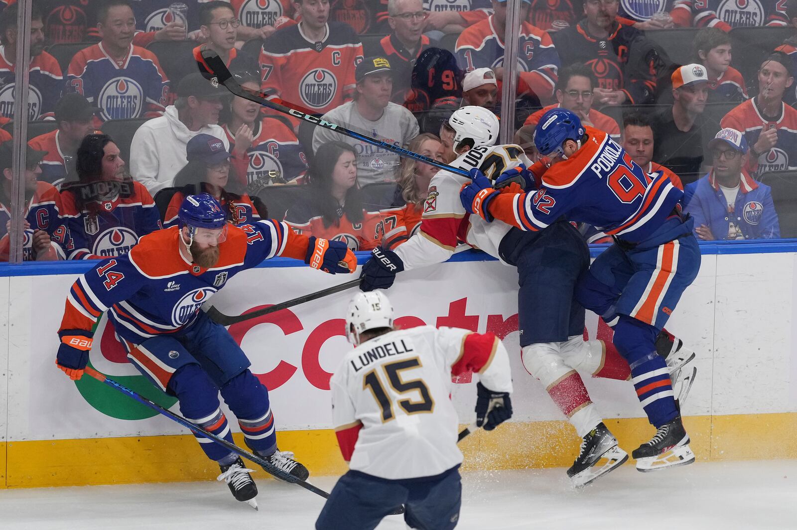 Edmonton Oilers' Vasily Podkolzin (92) checks Florida Panthers' Eetu Luostarinen during the first period in Game 1 of the NHL hockey Stanley Cup final series in Edmonton, Alberta, Wednesday, June 4, 2025. (Darryl Dyck/The Canadian Press via AP)