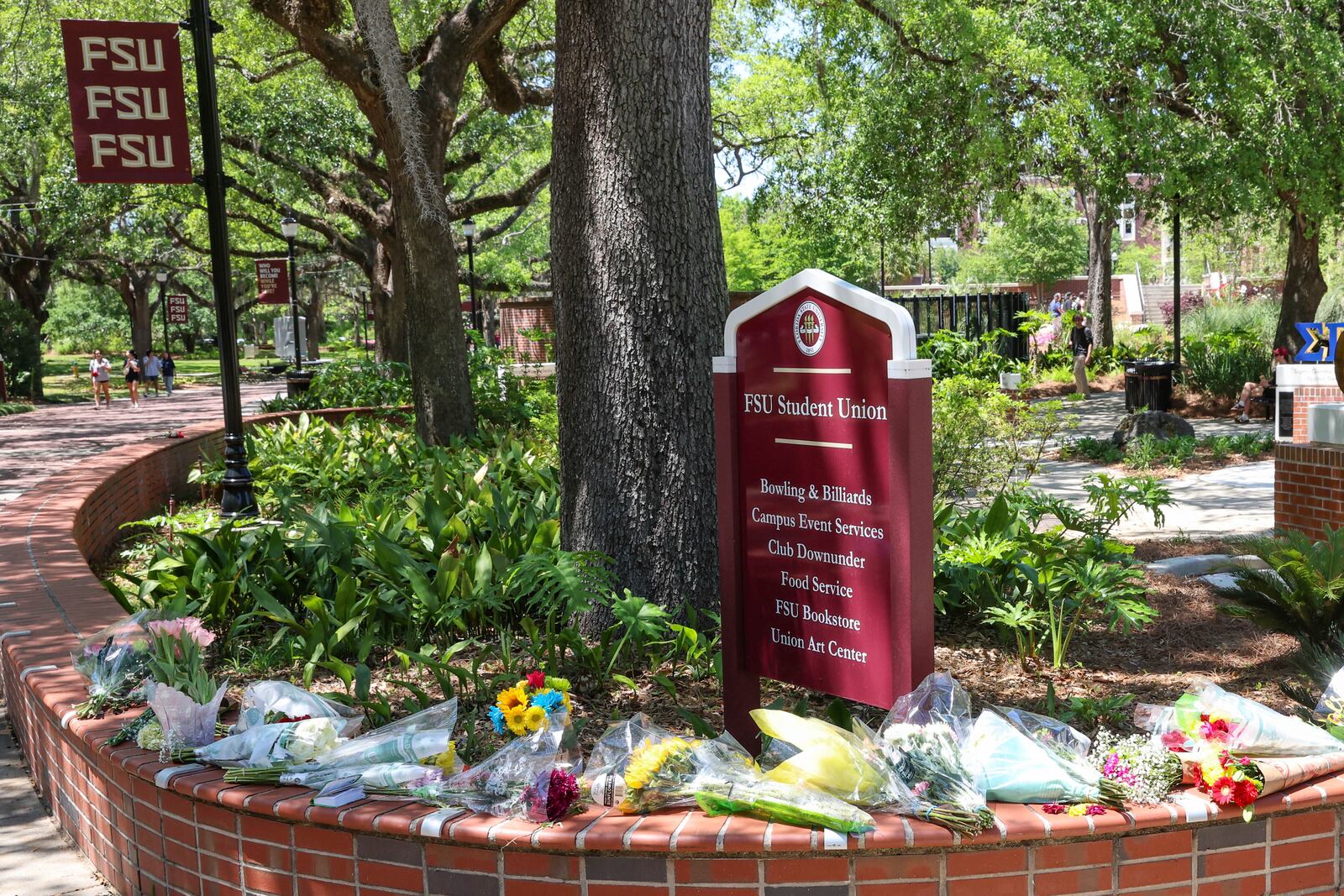 Flowers placed by students sit next to a sign for the Florida State Student Union building, Tallahassee, Fla., Friday, April 18, 2025. (AP Photo/Gary McCullough)