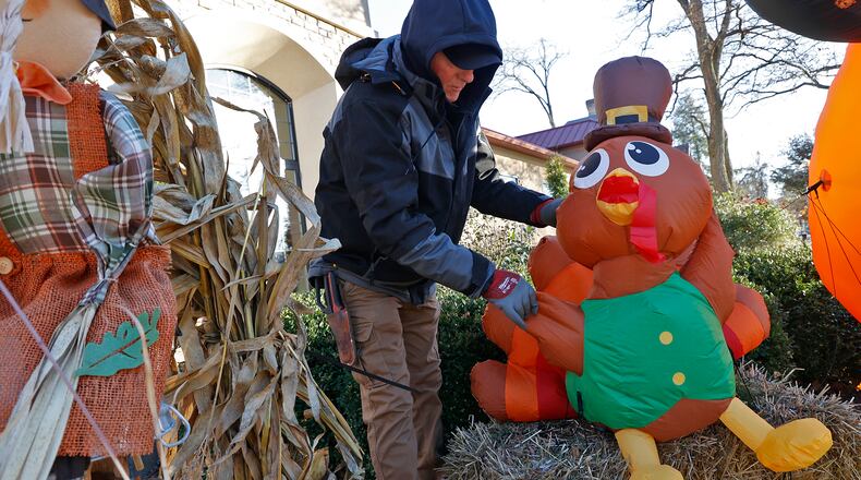George Roach, from George's Landscaping, sets a Thanksgiving turkey inflatable back up in front of the Madison Avenue Pharmacy Monday, Nov. 21, 2022. According to Roach, the wind has played havoc with the inflatable decorations this season and he's had to set them back up and anchor them with extra string several times. BILL LACKEY/STAFF