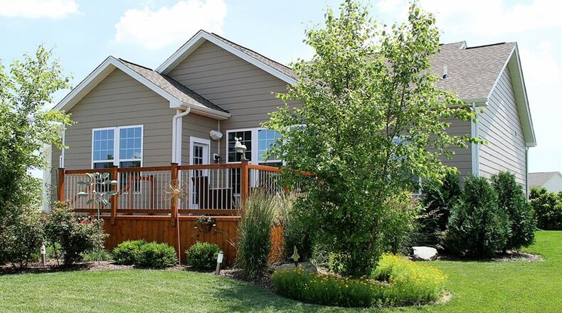 Patio doors open off the extended breakfast room out to the wooden deck and hidden circular paver-brick patio.