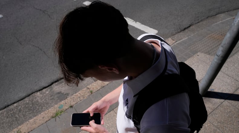 FILE - A teenage boy uses his phone in Sydney, Nov. 8, 2024. (AP Photo/Rick Rycroft, File)