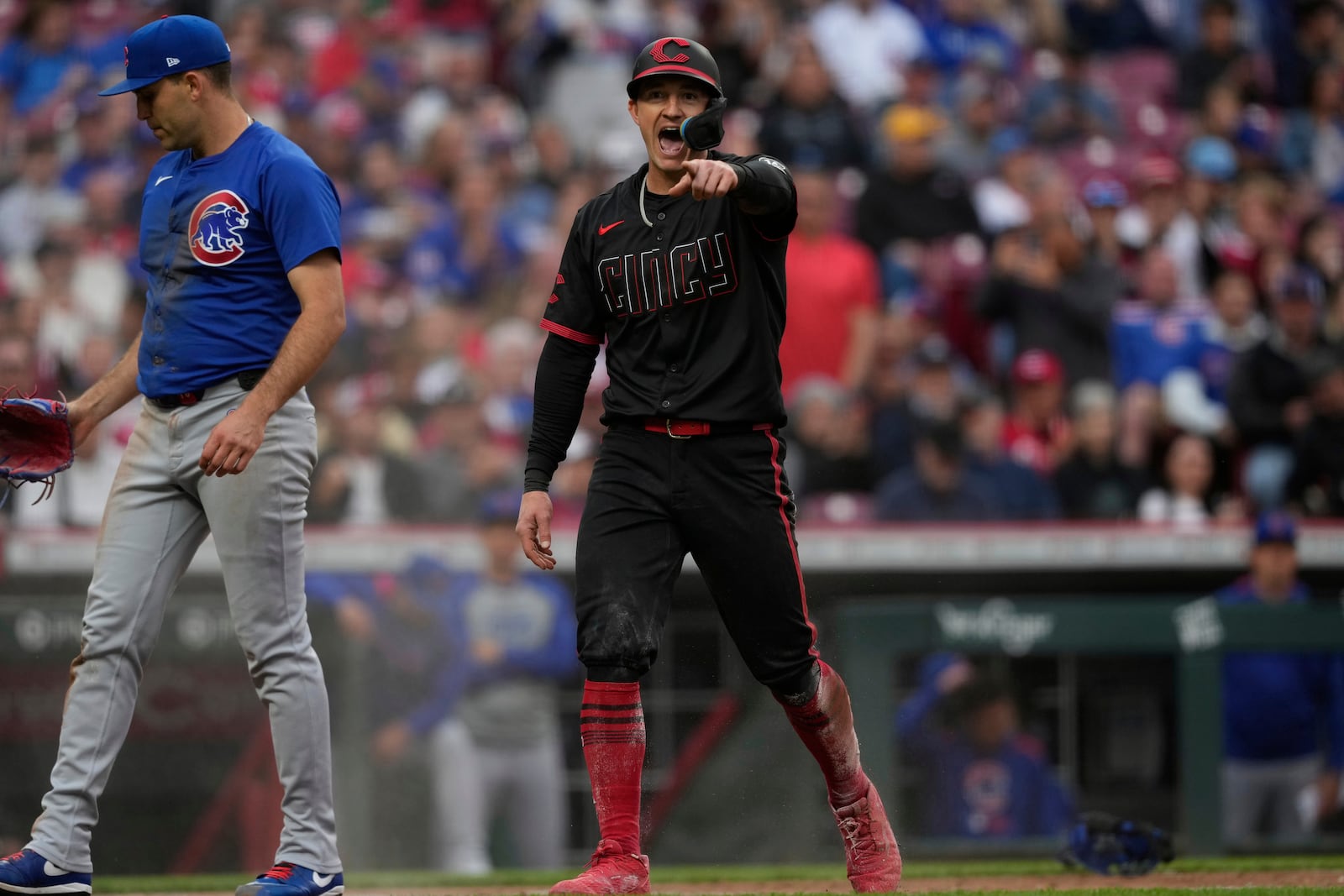Cincinnati Reds' Austin Hays, right, reacts after scoring on a wild pitch from Chicago Cubs pitcher Matthew Boyd, left, in third inning of a baseball game, Friday, May 23, 2025, in Cincinnati. (AP Photo/Carolyn Kaster)