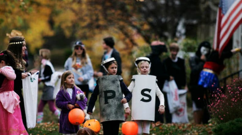 FILE  PHOTO: Trick or treaters by the hundreds make their way through Oakwood streets.