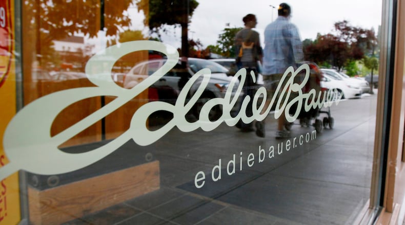 FILE - In this June 17, 2009, file photo, shoppers are reflected in the window as they walk past an Eddie Bauer store, in Seattle. (AP Photo/Elaine Thompson, File)