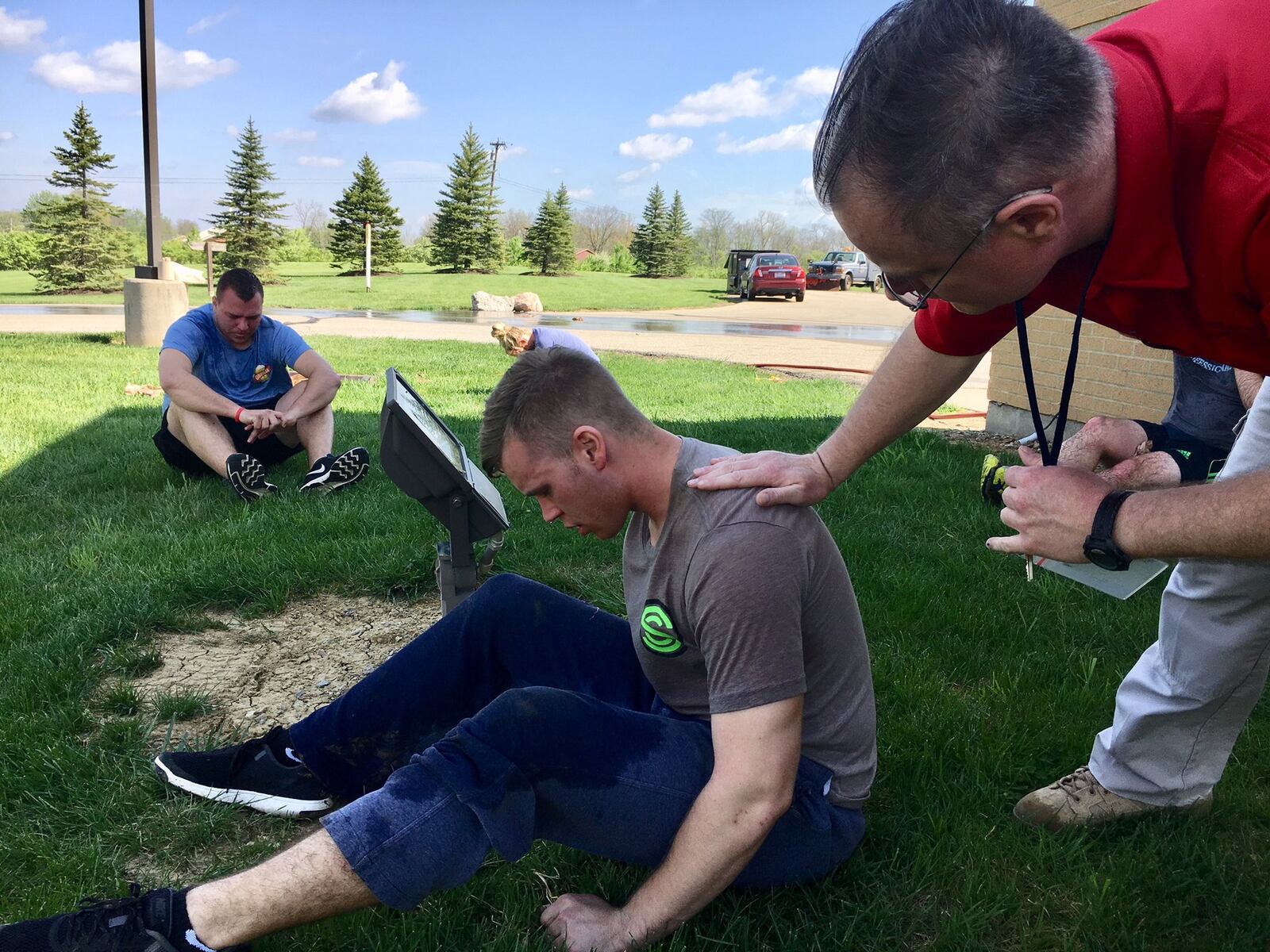 Part of the real-life lessons delivered at Butler Tech’s Police Academy in Liberty Twp. is for adult students to take shots of pepper spray directly in their faces. It’s not an act of cruelty, but rather a possible, life-saving experience should they accidentally be sprayed while wrestling a suspect. Pictured are students recovering — slowly — outside the academy with the help of water hoses, towels and lots of fresh air. 