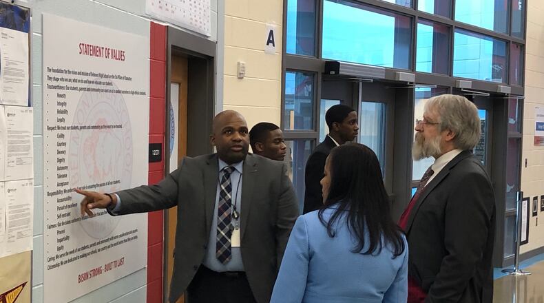 Belmont High School Principal Donetrus Hill shows some his school’s values to state Superintendent Paolo DeMaria and Dayton Public Schools Treasurer Hiwot Abraha, as two Belmont JROTC students wait to help. DeMaria toured several Dayton schools on Tuesday, Feb. 26, 2019. JEREMY P. KELLEY / STAFF