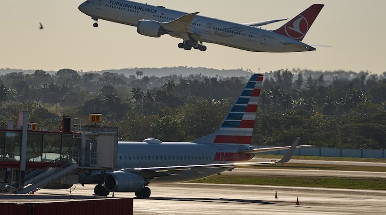 A Turkish Airlines plane takes off alongside an American Airlines plane at Jose Marti International Airport in Havana, Cuba, Monday, Feb. 9, 2026. (AP Photo/Ramon Espinosa)