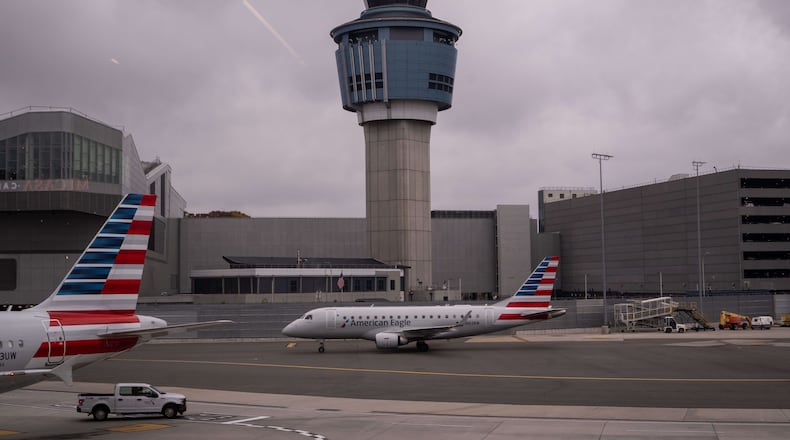 An American Eagle plane moves past the FAA Air Traffic Control tower at LaGuardia Airport (LGA) in the Queens borough of New York, Sunday, Nov. 9, 2025. (AP Photo/Adam Gray)