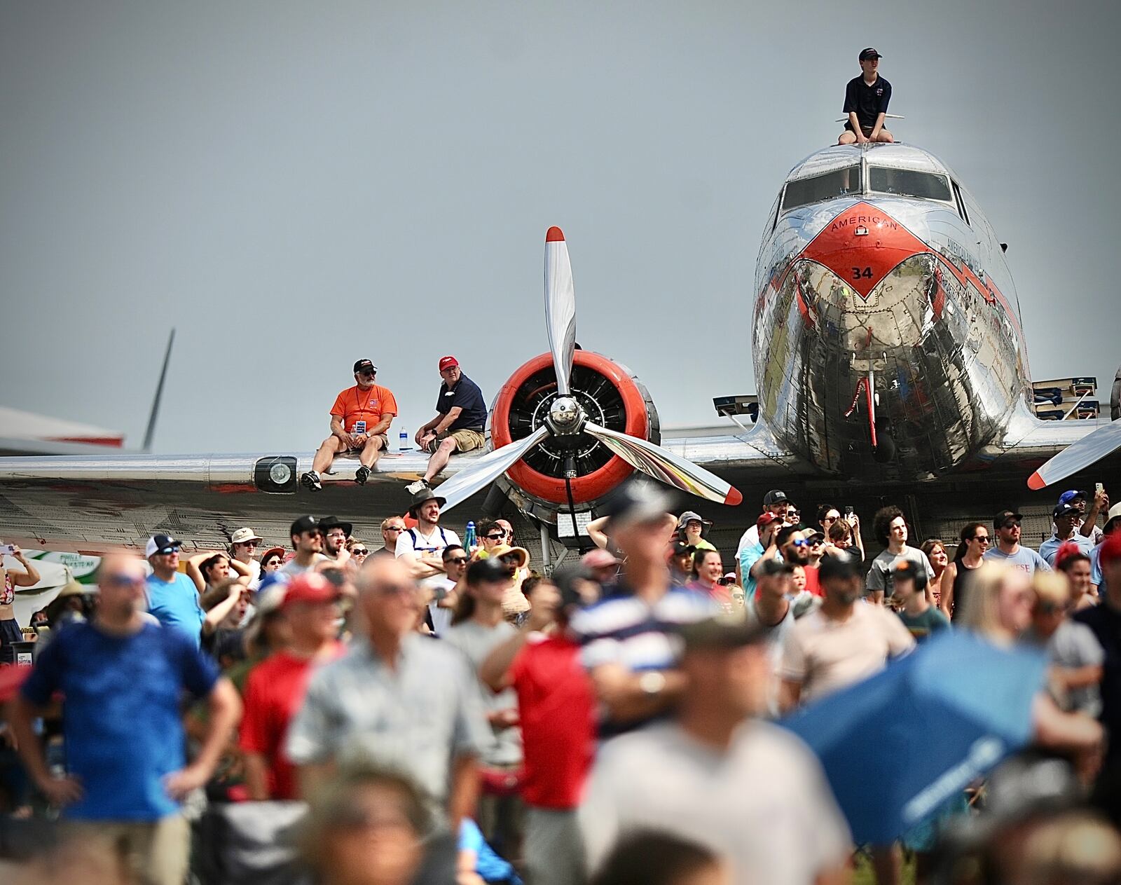 Patrons sit on the wings of the planes at the Dayton Air Show Sunday, July 23. MARSHALL GORBY/STAFF