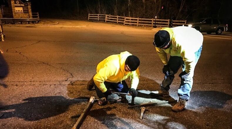Montgomery County Water personnel work on a valve under Shoup Mill Road the night of the water main break. JIM NOELKER / STAFF