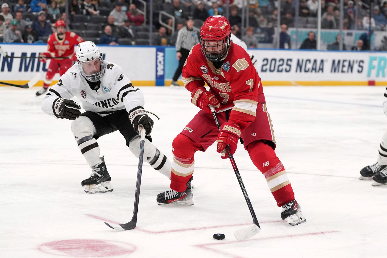 Denver's Aidan Thompson (7) handles the puck as Western Michigan's Cole Crusberg-Roseen (3) defends during the second period in a semifinal game in the NCAA Frozen Four men's college hockey tournament, Thursday, April 10, 2025, in St. Louis (AP Photo/Jeff Roberson)