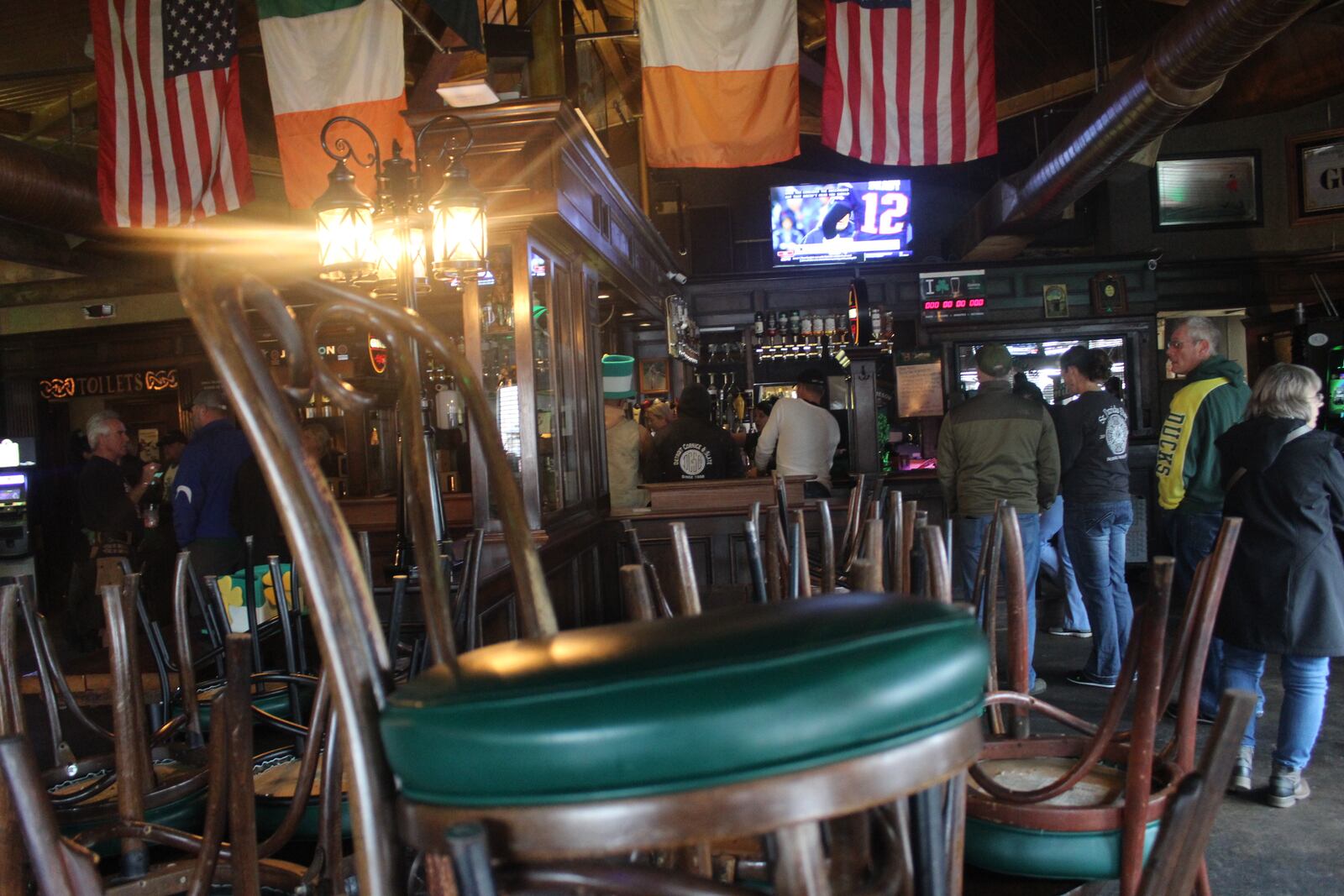 Streets were mostly empty in the Oregon District on St. Patrick's Day 2020 due to the coronavirus. Business owners pushed through or closed shop. Several restaurants are trying out carryout and/or delivery strategies. Some shops are testing online sale approaches.  Most of the foot traffic on the street was due to nearby residents walking dogs. Customers picking up orders inside of Dublin Pub are pictured.