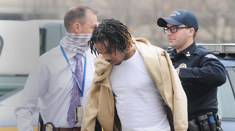 Ronald Gomez Taylor is escorted into the Dayton Public Safety building Monday morning, Dec. 21, 2020 after being transported by Trotwood police. Taylor was booked into the Montgomery County Jail on a charge of murder and a parole violation. He is being held in jail without bond, according to records.