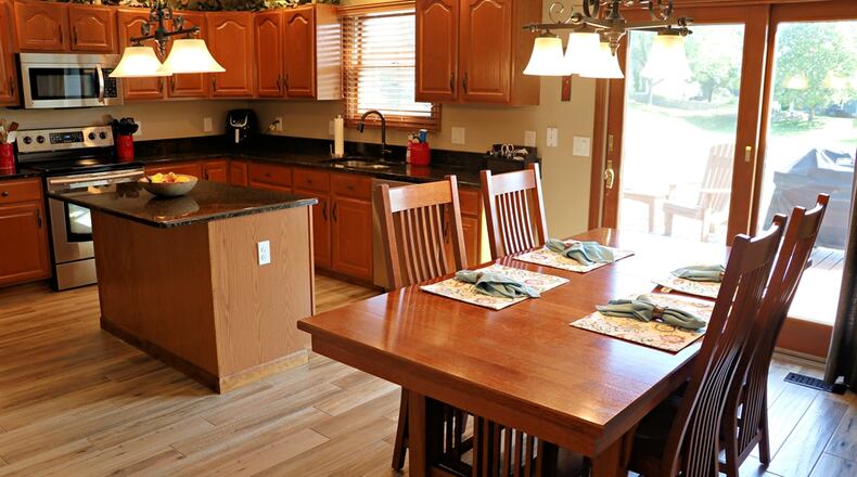 The kitchen was remodeled with granite counters, an island and stainless-steel appliances. Sliding patio doors open from the breakfast room to the deck and patio area. Contributed photos by Kathy Tyler