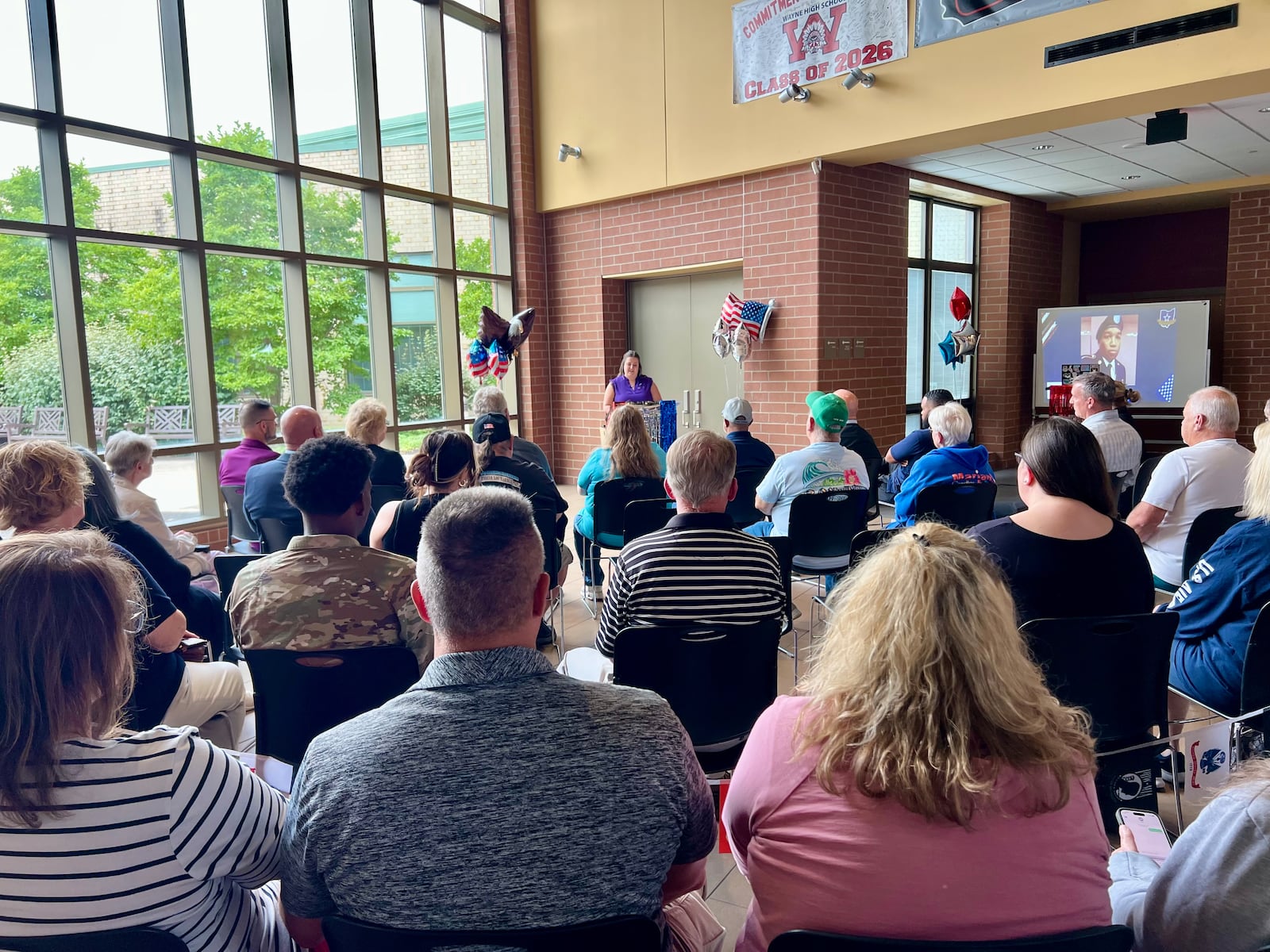 Huber Heights City Schools' Purple Star representative Jen Davis speaks to the crowd at the unveiling event of the Wayne High School Wall of Honor. AIMEE HANCOCK/STAFF