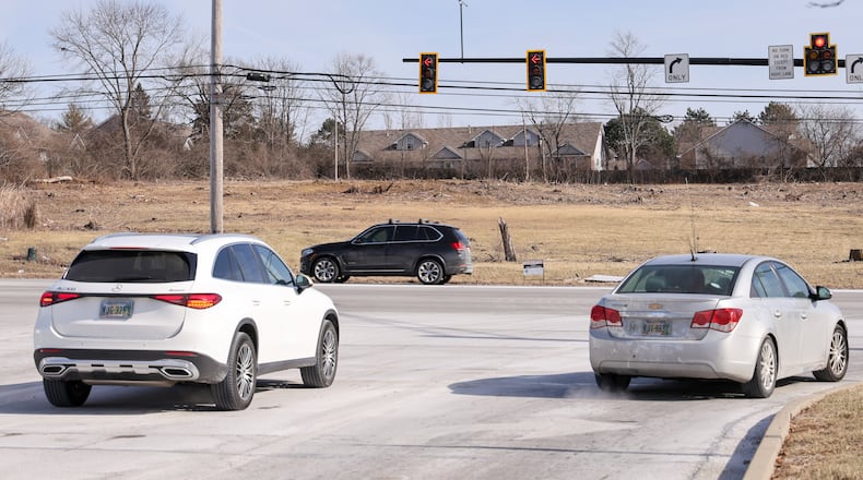 Cars wait to turn onto North Springboro Pike as they exit Austin Landing on Friday, Jan. 23. A new development called Austin Crossing is being built across North Springboro Spike from Austin Landing. BRYANT BILLING / STAFF