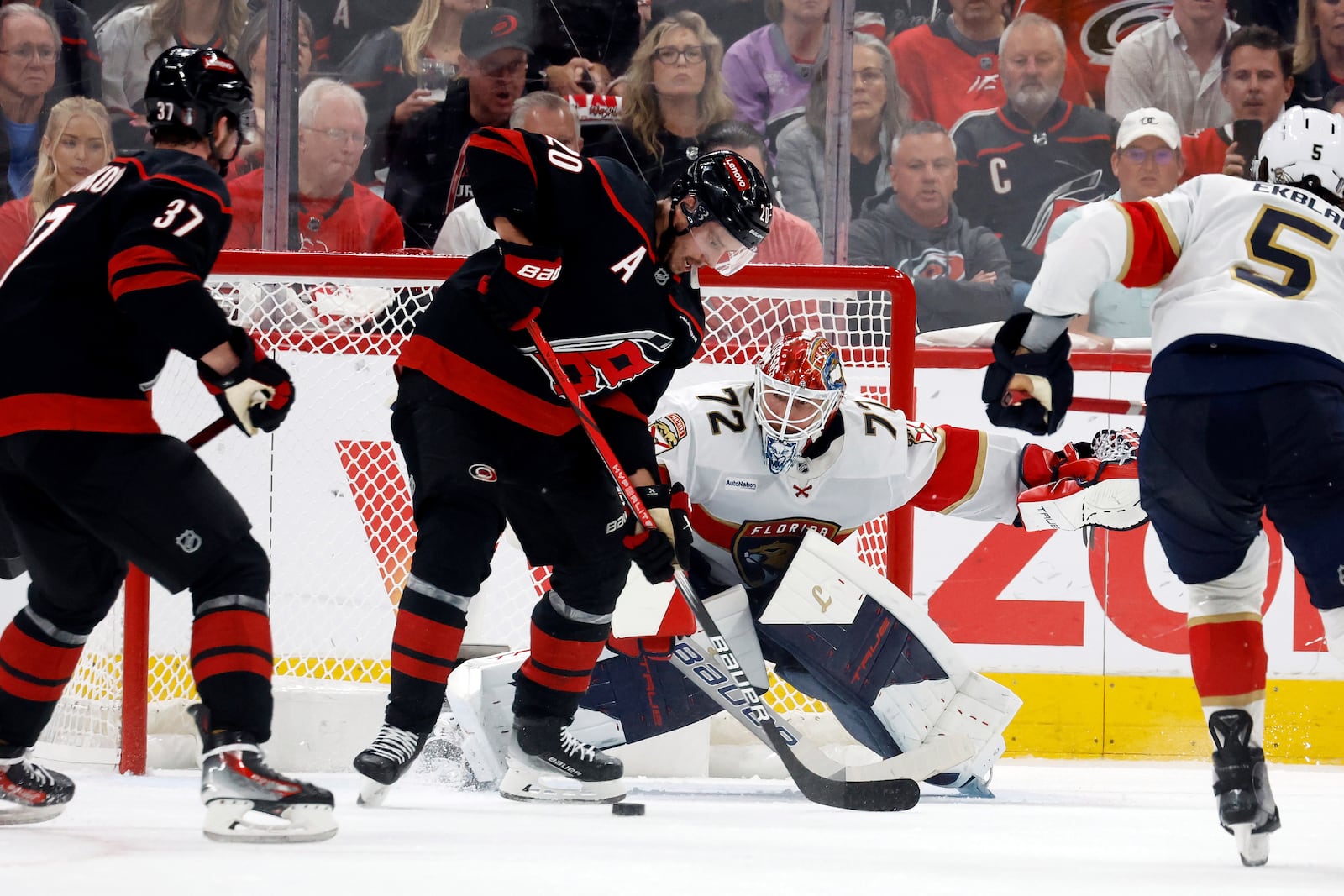 Carolina Hurricanes' Sebastian Aho (20) redirects the puck past Florida Panthers goaltender Sergei Bobrovsky (72) with Andrei Svechnikov (37) nearby during the first period of Game 1 of the NHL hockey Stanley Cup Eastern Conference finals in Raleigh, N.C., Tuesday, May 20, 2025. (AP Photo/Karl DeBlaker)