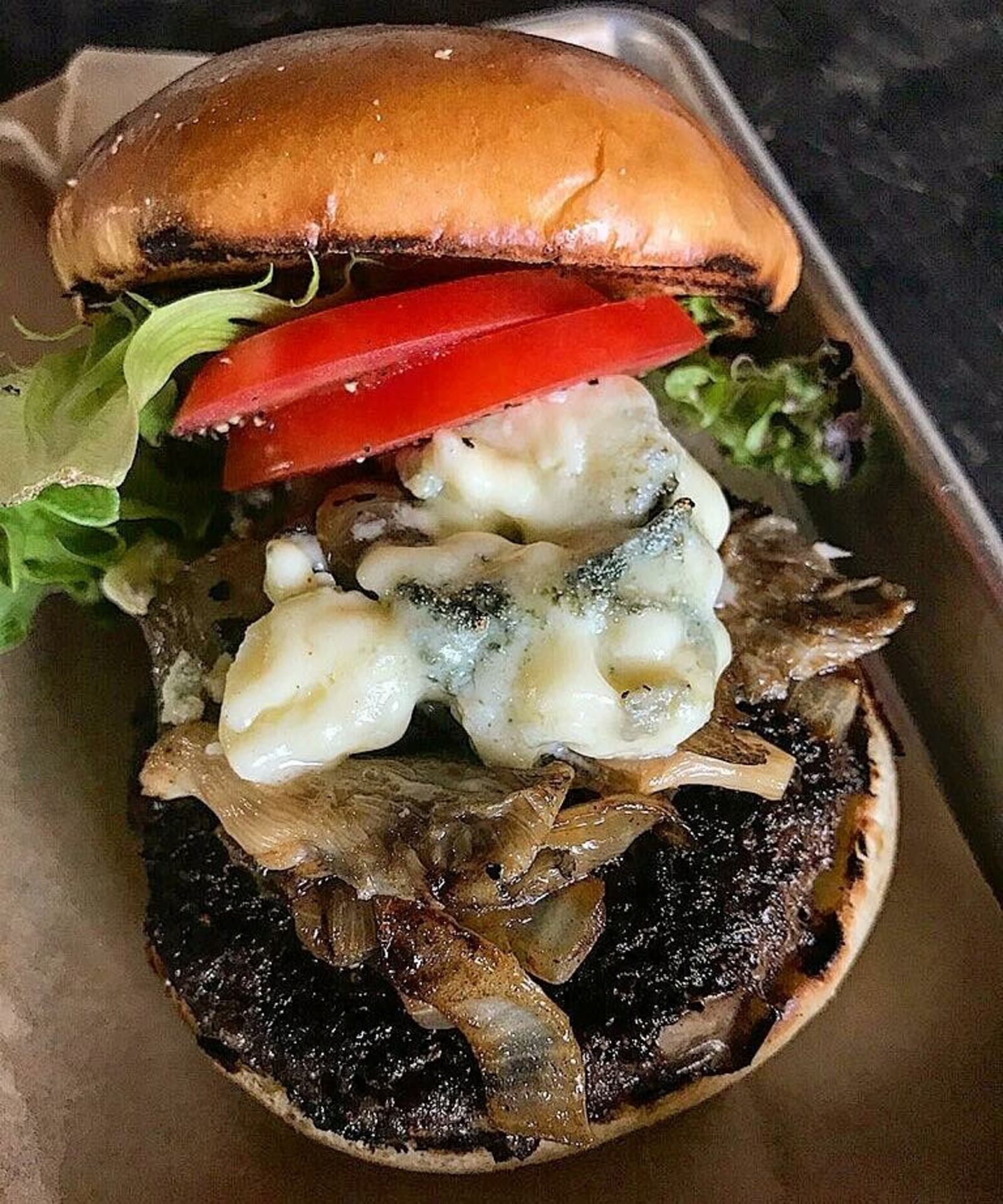 Mudlick's 1/3lb Grass-fed Blackhawk Farms Beef, Whiskey mushrooms, caramelized onion, cajun spice, gorgonzola on brioche. CONTRIBUTED