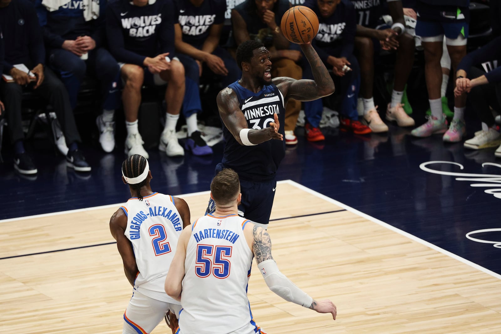 Minnesota Timberwolves forward Julius Randle (30) shoots against Oklahoma City Thunder guard Shai Gilgeous-Alexander (2) and center Isaiah Hartenstein (55) during the second half of Game 3 of the Western Conference finals of the NBA basketball playoffs, Saturday, May 24, 2025, in Minneapolis. (AP Photo/Matt Krohn)