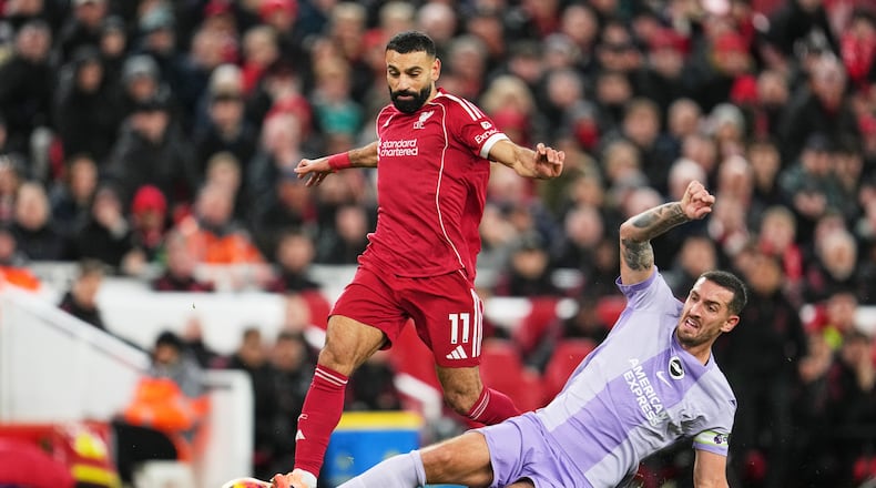 Liverpool's Mohamed Salah, left, challenges for the ball with Brighton's Lewis Dunk during the English Premier League soccer match between Liverpool and Brighton and Hove Albion in Liverpool, England, Saturday, Dec. 13, 2025. (AP Photo/Jon Super)