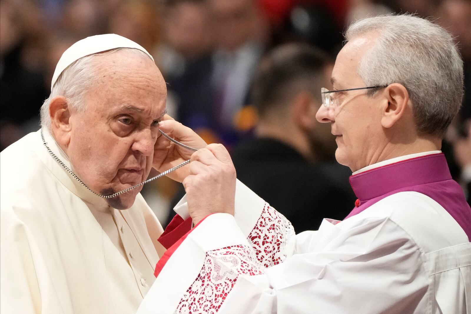 FILE - Pope Francis is helped by his aide Archbishop Diego Giovanni Ravelli, right, as he arrives for the start of a public consistory to elevate 21 new cardinals, in St. Peter's Basilica, at the Vatican, Saturday, Dec. 7, 2024. (AP Photo/Gregorio Borgia, file)