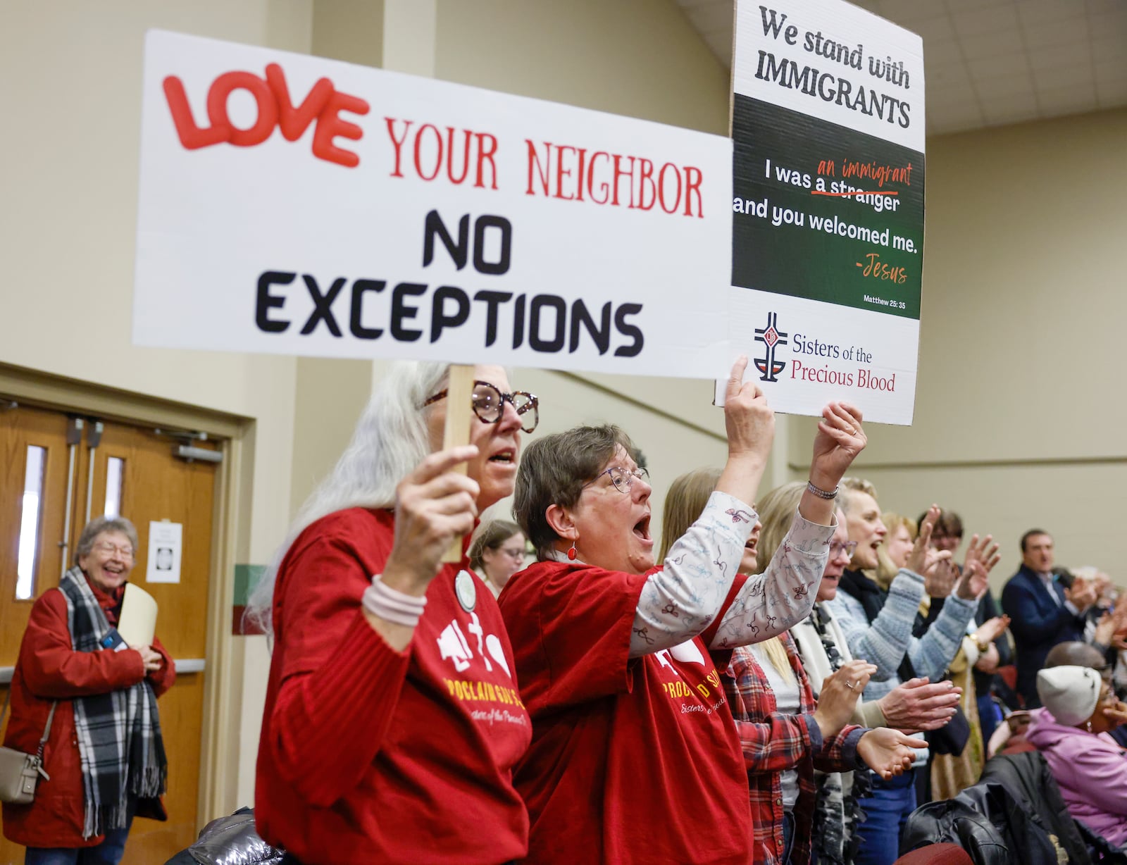 Audience members sing along to praise songs and hold pro-immigration signs during Here We Stand: Faith Leaders for Immigration Justice & Family Unity at St. John Missionary Baptist Church on Monday, Feb. 2, 2026, in Springfield. Pastors, faith leaders and community members gathered to pray and call for the extension of Temporary Protected Status which is scheduled to expire on Tuesday, Feb. 3, 2026. JOSEPH COOKE/STAFF