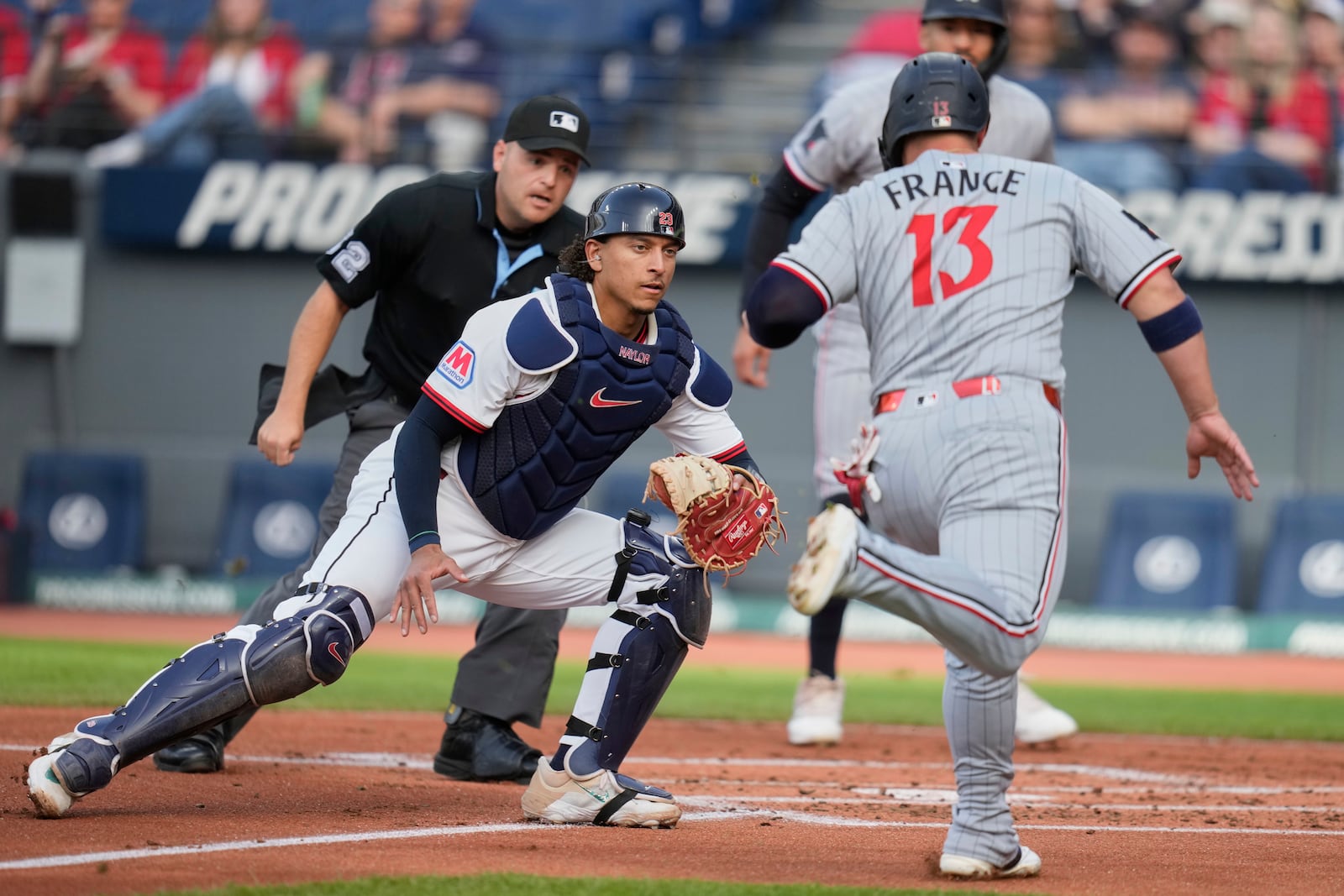 Cleveland Guardians catcher Bo Naylor prepares to tag out Minnesota Twins' Ty France (13) at home plate in the first inning of a baseball game in Cleveland, Monday, April 28, 2025. (AP Photo/Sue Ogrocki)