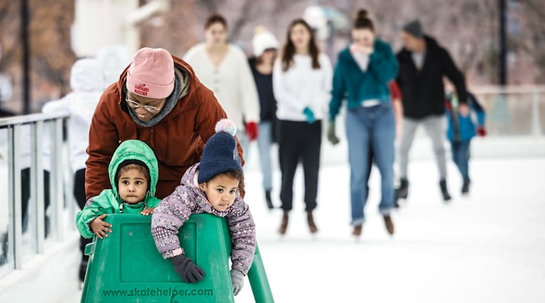 Hope Jeter pushes Fatima Jeter and Avery Gharst on a warm winter day at Five Rivers MetroPark ice rink at RiverScape Thursday December 26, 2024. Warm weather will continue into next week. JIM NOELKER/STAFF