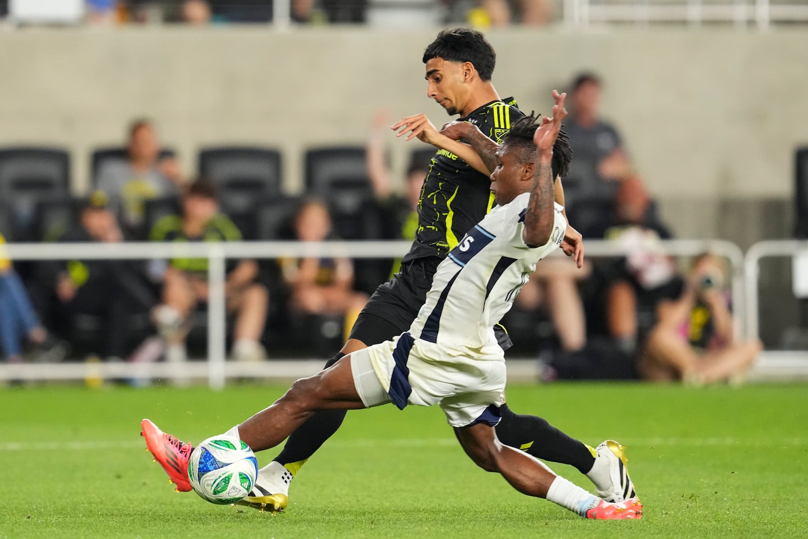 Vancouver Whitecaps defender Édier Ocampo, right, tackles Columbus Crew midfielder Taha Habroune, left, during the second half of an MLS soccer match Saturday, June 14, 2025, in Columbus, Ohio. (AP Photo/Jeff Dean)