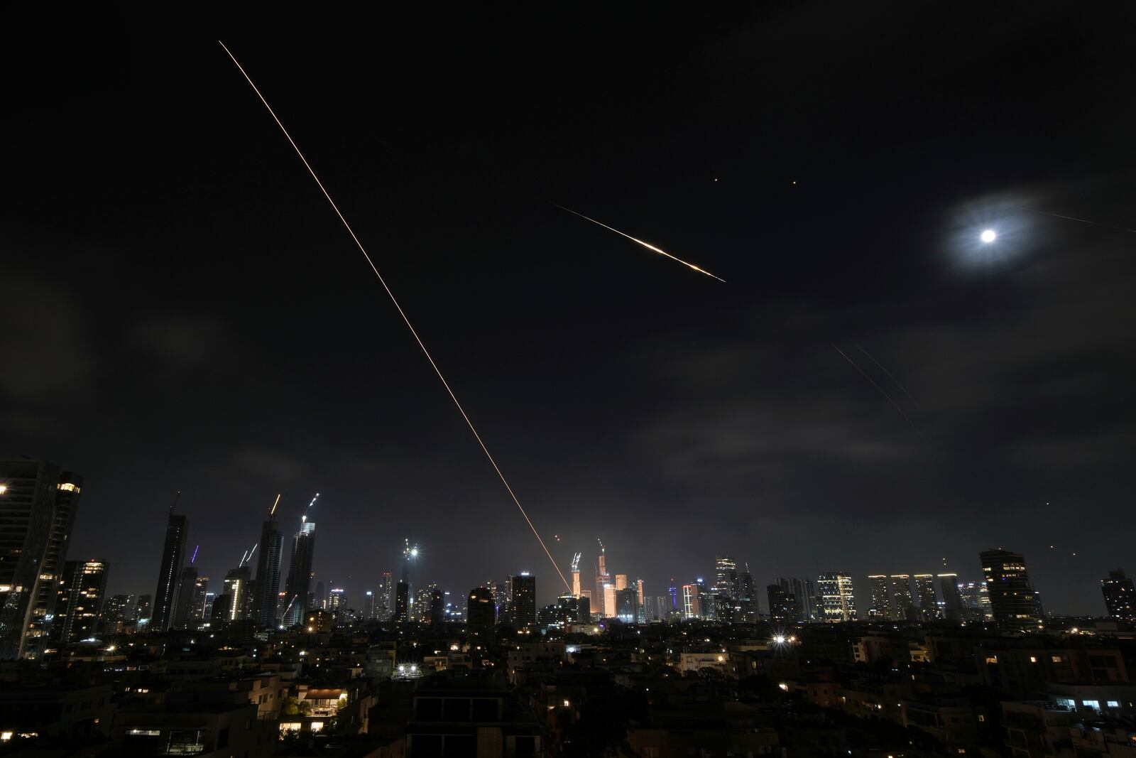 The trace of a projectile is seen as it hits buildings in Tel Aviv, Israel, early Saturday, June 14, 2025. (AP Photo/Leo Correa)