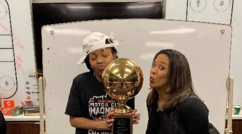 (cutline: Angel Baker (left) and Wright State head coach Katrina Merriweather smooch the Horizon League trophy after the Raiders defeated Green Bay in the championshp game March 12, 2019. CONTRIBUTED