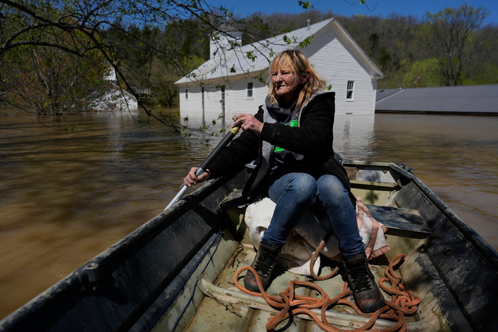Resident Wanona Harp paddles past churches in Lockport, Ky., flooded by the Kentucky River, Tuesday, April 8, 2025. (AP Photo/Carolyn Kaster)