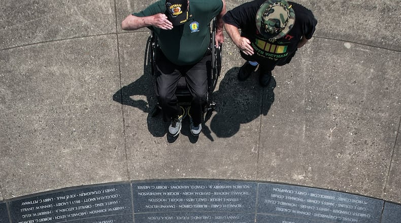 Vietnam veterans Michael Vanderveen left, and David Fuchs salute fallen soldiers at the Vietnam Veterans Memorial Park in Dayton Friday May 19, 2023. JIM NOELKER/STAFF