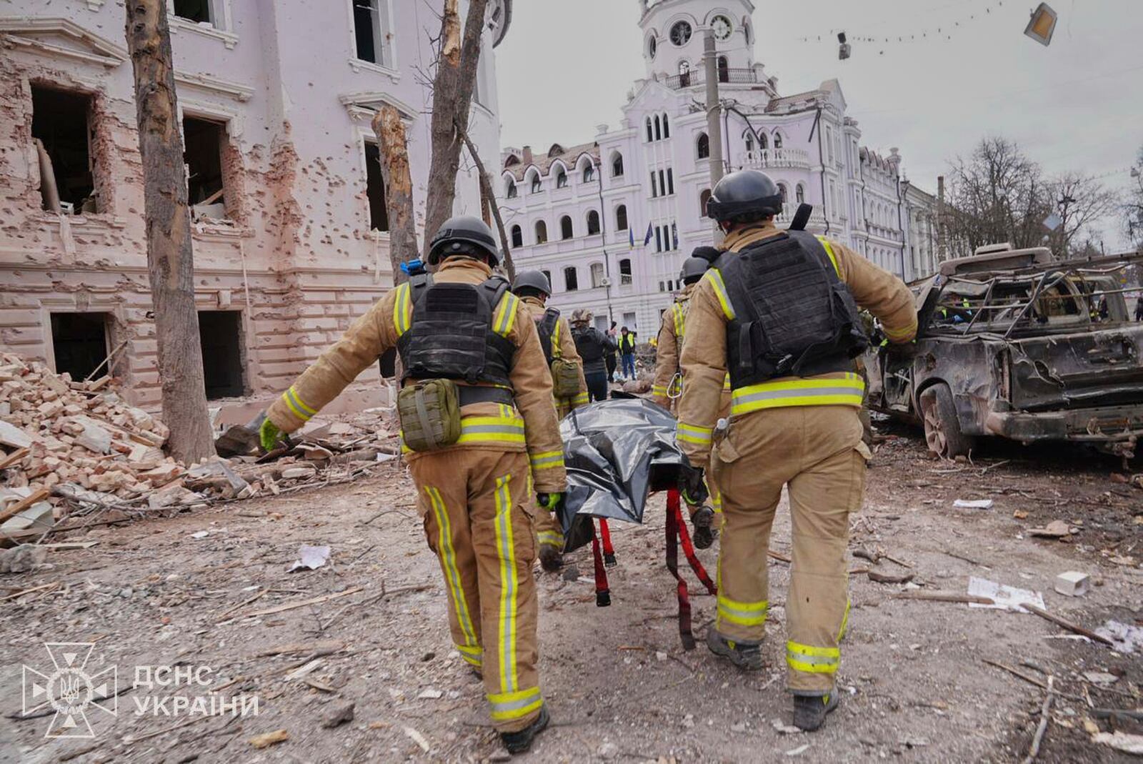 In this photo provided by the Ukrainian Emergency Service, firefighters carry a body of the victim following Russia's missile attack that killed at least 24 civilians in Sumy, Ukraine, Sunday, April 13, 2025. (Ukrainian Emergency Service via AP)